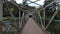 Skilled flying of FPV Drone inside iron bridge over the river on sunny summer day.