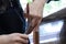 skilled Hands of a hairdresser cutting the curly wavy hair of a customer with hand scissors and a comb