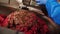 Skilled laborer in gloves pours minced meat in shop closeup