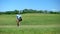 Skilled male golf trainer walking on course with clubs bag recreational activity