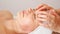 Skilled masseur runs fingers on beauty salon client forehead