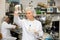 Skilled middle-aged female biochemist examining solution in test tube for chemical reaction in research center