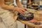 Skilled pottery master gently processing piece of wet clay