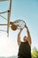 Skilled sportive guy throwing ball into basket, while playing basketball outdoors