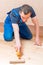 Skilled young worker paint roller on a wooden floor