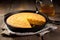 a skillet of bbq cornbread on a wooden table