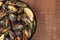 Skillet of marinara mussels on rustic background with copy space