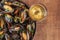 Skillet of marinara mussels on rustic background with wine and place for text