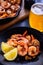 Skillet roasted jumbo shrimp with sliced garlic and spices on a black plate