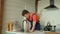 Skillful African American male plumber replacing old sink strainer in kitchen