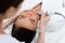 Skillful beautician doing facial laser skincare procedure