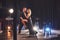 Skillful dancers performing in the dark room under the light