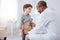 Skillful male doctor hearing boy