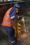 Skillful metal worker working with arc welding machine in factory while wearing safety equipment. Metalwork manufacturing and cons
