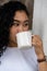 Skillfully composed, the mockup image highlights a woman presenting a white mug, effortlessly striking a simple pose, offering an