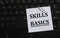 SKILLS BASICS - words on a white sheet against the background of the laptop keyboard
