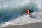 Skim Boarder riding a shore break wave at Aliso Beach in Laguna Beach, California.