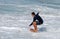 Skim Boarder riding toward a shore break wave at Aliso Beach in Laguna Beach, California.