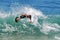 Skim boarder riding wave at Brooks Street Beach, Laguna Beach, CA