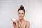 Skin care. Beauty Concept. Young woman holding cosmetic moisturizing cream. Soft skin and naked shoulders, model with light nude m
