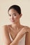 Skin Care. Beauty Portrait Of Asian Model. Ethnic Girl With Smooth Skin Touches Her Shoulder And Looking At Camera.