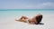 Skin care and body care - woman sun tanning with perfect skin on beach