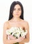 Skin care concept. Girl on calm face stands naked and holds chamomile flowers in front of chest. Beautiful woman with