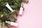 Skin care cosmetics bottles on a fir branches background. Blank containers on a pink background. Christmas present for women. Wint