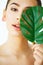 Skin Care. Green Leaf Shading a Half of Beautiful Woman Face. Be