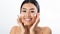 Skin care. Joyful asian woman applying hydration cream on cheeks