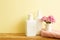 Skin care and spa concept. Bathroom bottles and towel with pink flowers on wooden shelf