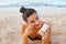 Skin care. Sun protection. Beautiful Woman In Bikini apply sun cream on Face. Beauty Woman With Suntan Lotion On Beach.