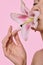 Skin care and women beauty. Female holding lily in mouth, flower petal on her lips. Promo of facial products for soothing,