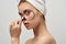 skin problems with acne woman with towel on head clothes magnifying glass near face