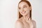 Skincare and beauty. Close-up of young woman with pale skin and freckles standing naked on white background, turn left