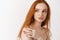 Skincare and beauty concept. Close-up of tender young redhead woman with pale skin, natural ginger hair, touching