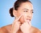 Skincare, beauty and woman squeeze pimple before a natural cosmetic face treatment in a studio. Acne, cosmetics and