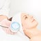 Skincare cosmetology facial procedure. Beauty woman face. Blue light medical therapy. Specialist hand