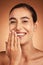 Skincare, hand and woman in studio for skin, makeup and beauty on orange background, happy and relax. Hand, portrait and