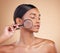 Skincare, model face or woman with magnifying glass in studio on beige background searching for beauty. Facial, eyes