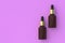 Skincare serum in dropper bottles on pink background. Top view. Copy space