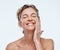 Skincare, smile and a woman with an anti aging cream isolated on a white background in a studio. Happy, moisturize and a