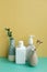 Skincare soap, shampoo, conditioner bottle on green table. yellow wall background