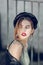 Skinny beautiful lady with unusual hairstyle having leather fedora hat