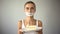 Skinny girl with taped mouth holding cake, refuses to eat sweet, low-carb diet