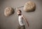 skinny guy lifting large rock stone weights