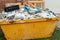 Skip bin full of household waste rubbish on the front yard. House clean up and renovation concept