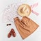 Skirt, shirt, straw boater hat, leather brown sandals on white background.