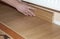 Skirting Board & Architrave. Repairman hands Installing Skirting Board Oak Wooden Floor with Glue. Flooring and Repair.