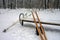 Skis and ski poles on a snow-covered bench